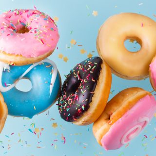 Flying doughnuts scene - mix of multicolored sweet donuts with sprinkel on blue background